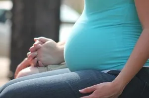 A close-up of a pregnant woman's baby bump.
