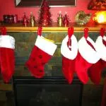 A close-up of Christmas socks hanging at the top of a fire furnace.