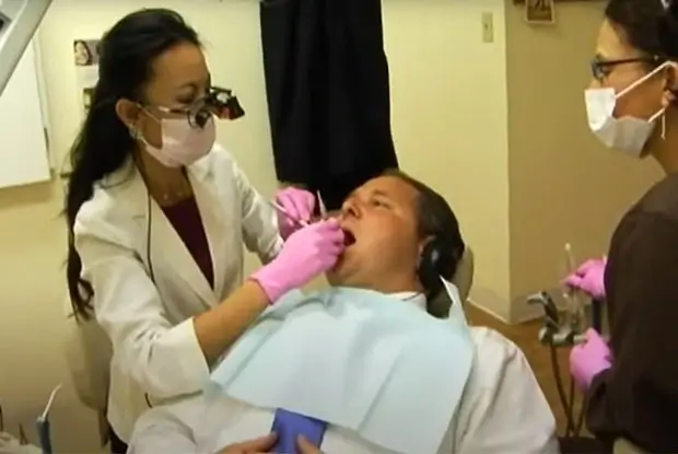 A close-up of Dr. Nancy Nguyen and a nurse assistant performing a dental treatment on a patient.